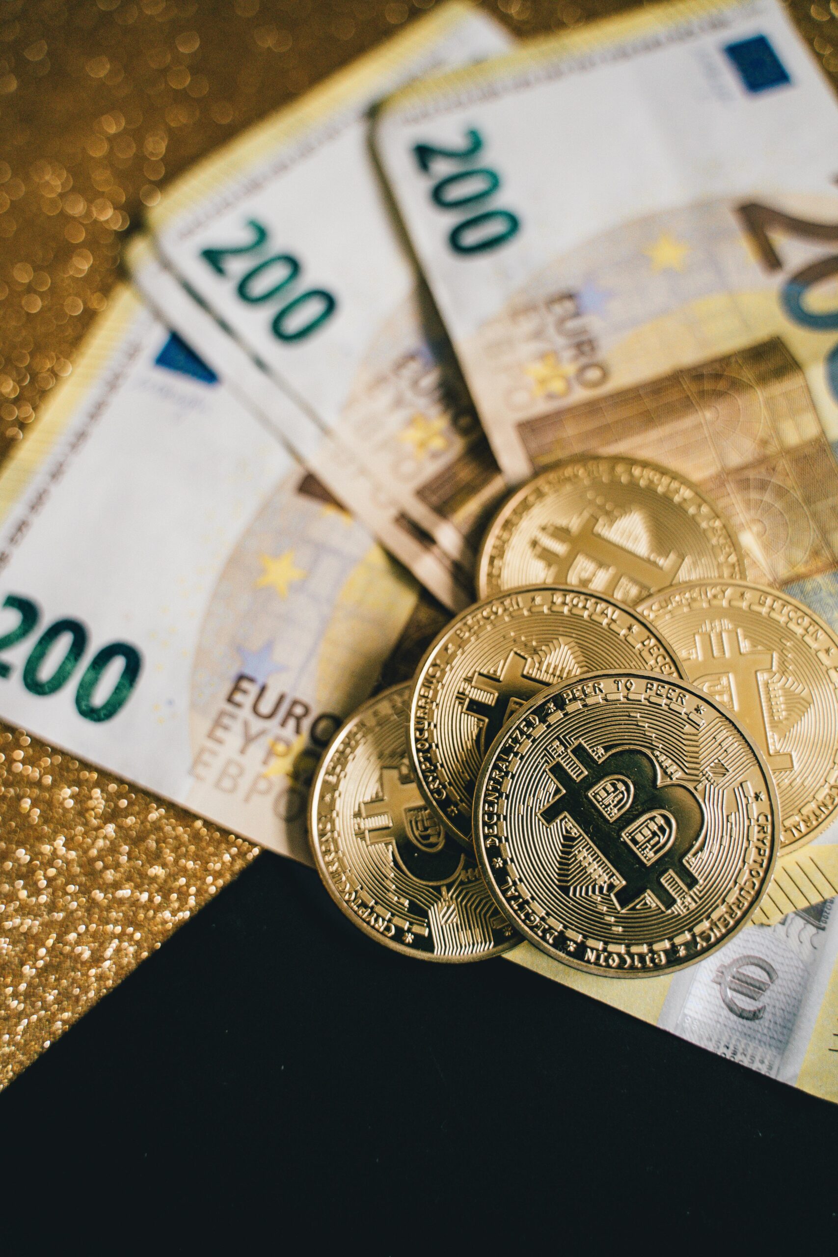 Close-up of Euro banknotes with Bitcoin coins on a glittery background symbolizing modern currency and investment.